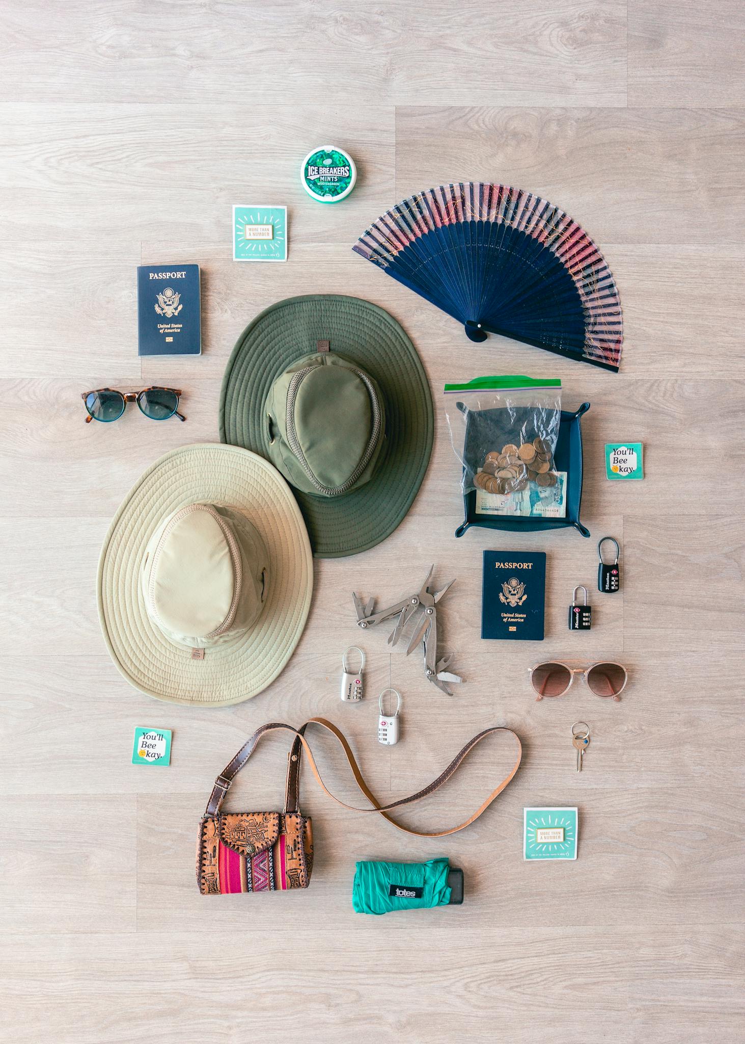 Flat lay of travel essentials including passports, hats, and accessories, perfect for packing inspiration.